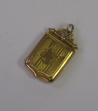 An Edwardian 9ct gold shield shaped locket 