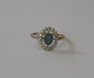 A 9ct gold dress ring set an oval cut blue stone  surrounded by diamonds