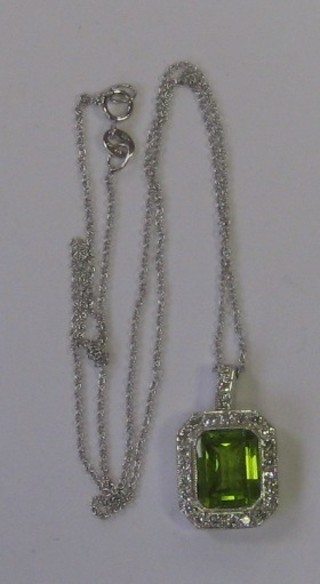 A lady's attractive 18ct white gold pendant set a square cut peridot surrounded by numerous diamonds, approx 0.40/3.60ct