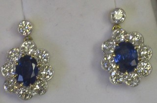A pair of earrings set oval cut sapphires surrounded by numerous diamonds, approx 1.70/2ct