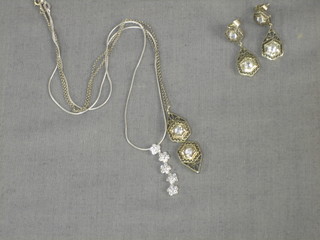 An 18ct white gold chain hung a pendant, 1 other chain hung a pendant set white stones and a matching pair of earrings
