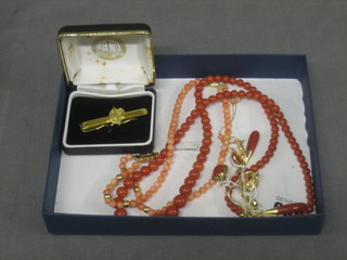 A string of coral coloured beads with matching earrings etc