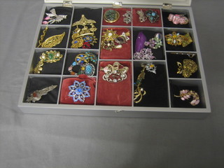 A display case containing a collection of various brooches