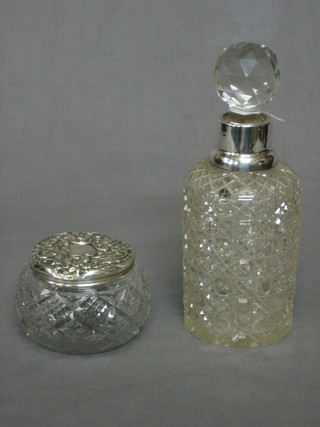 A cylindrical cut glass bottle (cracked) with silver collar and a circular cut glass dressing table jar
