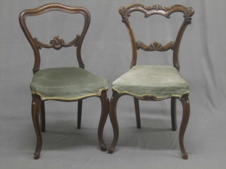 A pair of Victorian carved walnut balloon back chairs with shaped mid rails, the seats of serpentine outline, raised on cabriole supports
