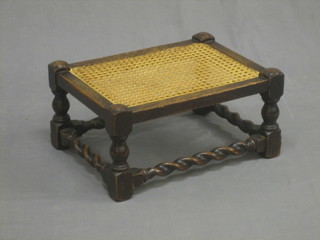 An oak stool with woven rush seat, raised on turned and block supports with spiral turned stretcher 17"