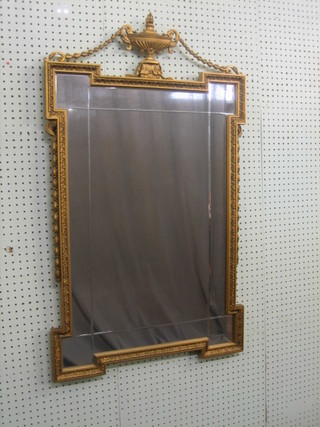A rectangular shaped cut and plate glass mirror contained in a gilt frame surmounted by an urn 40"