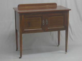 An Edwardian inlaid mahogany wash stand enclosed by panelled doors, raised on square tapering supports 36"