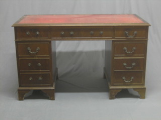 A Georgian style mahogany kneehole pedestal desk with inset red leather writing surface, above 1 long and 8 short drawers, raised on bracket feet 48"
