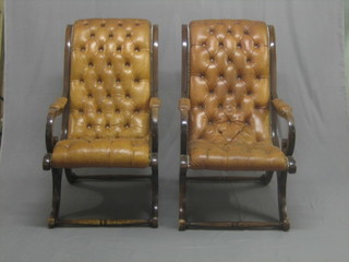 A pair of Georgian style mahogany open arm chairs upholstered in orange buttoned back leather, raised on sabre supports