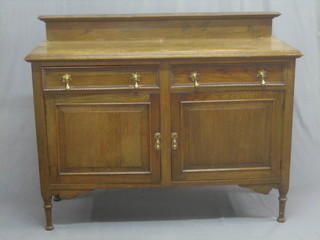 A honey oak sideboard fitted 2 drawers above a double cupboard with brass drop handles, raised on turned feet 54"