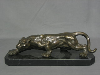A modern bronze figure of a walking Jaguar, raised on a lozenge shaped marble base (chipped) 17"