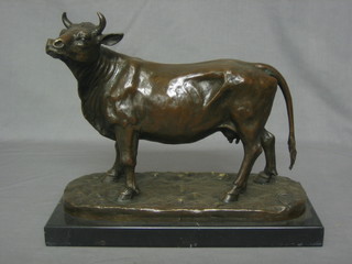 A modern reproduction bronze figure of a standing cow, raised on a marble base 13 1/2"