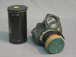 A WWII Civil Defence respirator and a cylindrical metal canister containing various lenses and filters etc