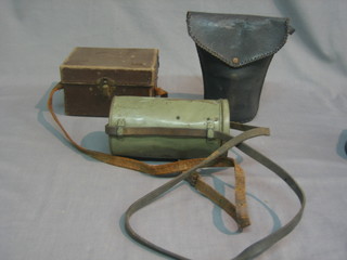 A WWII cylindrical metal gas mask, cased and 4 other gas masks all cased
