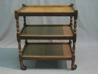 An oak 2 tier tea trolley on turned and block supports 24"