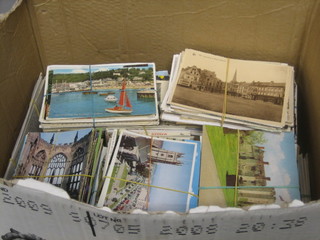 A box containing a large collection of various postcards