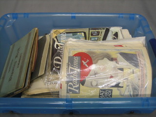A collection of various old newspapers, in a green plastic tray