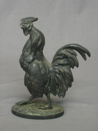 A 19th Century French bronze figure of a walking cockerel raised on an oval base 7"