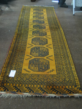 A tan ground Afghan runner with 9 octagons to the centre 115" x 30"