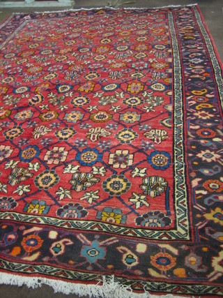 A red ground and floral patterned Persian rug 122" x 85"