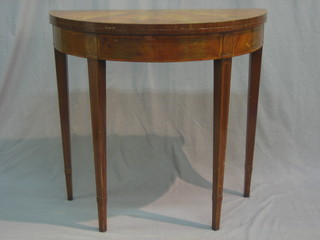 A Georgian style mahogany demi-lune card table with cross banded top and ebonised stringing, raised on square tapering supports 33"