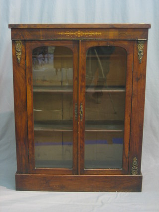 A Victorian mahogany display cabinet, the interior fitted shelves enclosed by arch shaped panelled doors, with gilt metal mounts 32"