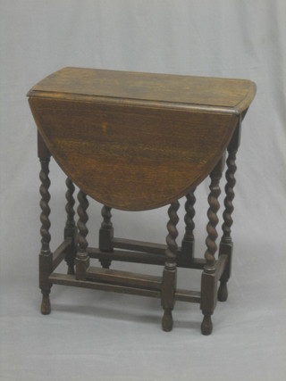 An oak oval drop flap gateleg tea table, raised on spiral turned supports 23"