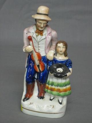 A 19th Century Staffordshire figure of a standing Minstrel playing a violin and child 8"