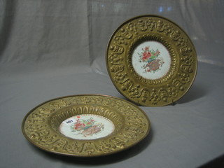 A pair of 18th/19th Century circular famille rose porcelain plates contained in an embossed brass mounts 12"