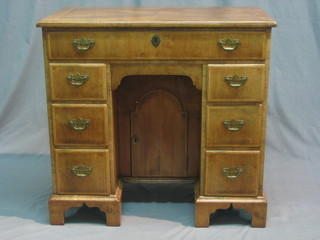 A Georgian style bleached mahogany kneehole pedestal dressing table/desk, the crossbanded top above 1 long drawer and secret drawer, the pedestal fitted a cupboard flanked by 6 short drawers, raised on bracket feet 32"