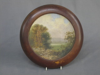 A 19th Century circular terracotta plate with landscape decoration contained in a socle frame 7"