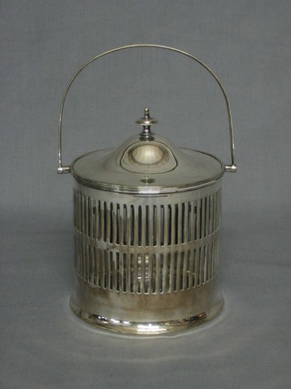 A cylindrical pierced silver plated biscuit barrel with swing handle and glass liner