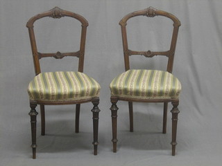 A set of 6 Victorian carved walnut balloon back dining chairs with carved mid rails and upholstered seats, raised on turned supports