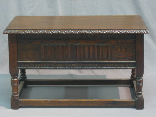 A rectangular carved oak stool, the seat with hinged lid, raised on turned and block supports 30"