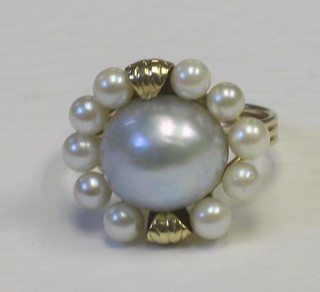 A lady's gold cluster dress ring, set a large grey pearl and surrounded by pearls