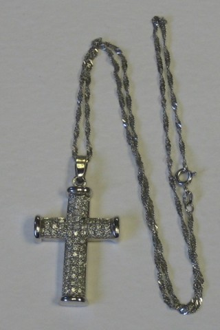 A lady's white gold cross set numerous diamonds hung a fine chain