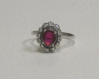 An 18ct white gold dress ring set an oval ruby (chipped) supported by diamonds