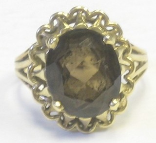 A 14ct gold dress ring set an oval brown coloured stone