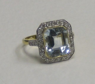 A lady's 18ct gold dress ring set a large aquamarine surrounded by diamonds, approx 0.55ct/4ct