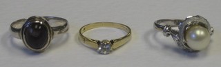 A silver dress ring set a cabouchon cut purple stone, a 9ct gold dress ring set a white stone and a dress ring set a "pearl"