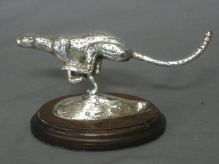 A silvered model of a running cheetah, raised on a wooden base, the base marked AfriSilver 7"