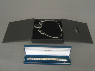 A silver bracelet together with a silver and black polished hardstone necklace