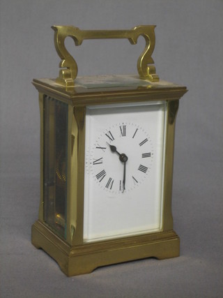 A 20th Century carriage clock with enamelled dial and Roman numerals contained in a gilt metal case