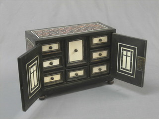 A 19th Century Anglo Indian ebony and tortoiseshell cabinet, the interior fitted numerous drawers and enclosed by a pair of panelled doors (with replacement hinges) 16"