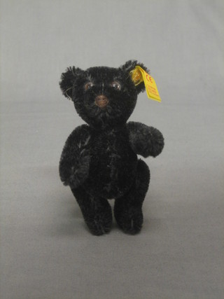 A black modern Steiff teddybear with articulated limbs, the label to the ear marked 030505, 4"