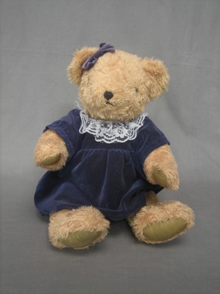 A gold coloured articulated bear from the Plush Toy Company with blue velvet dress and bow