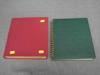 A green stock book of World stamps and a red stock book of World stamps