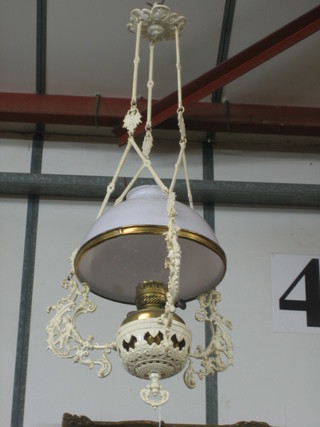A Victorian cast iron hanging oil lamp frame with brass reservoir and white glass shade (slight chip to the shade)