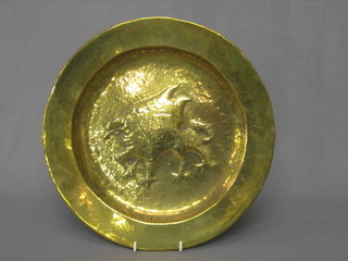 A circular embossed brass dish decorated a dragon 12"